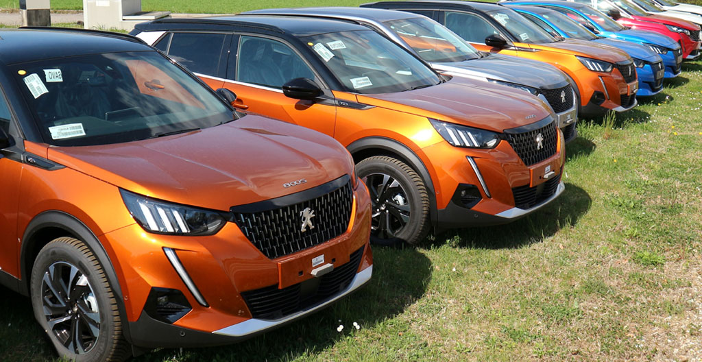 Client observant un SUV Peugeot dans un showroom lumineux de concession automobile